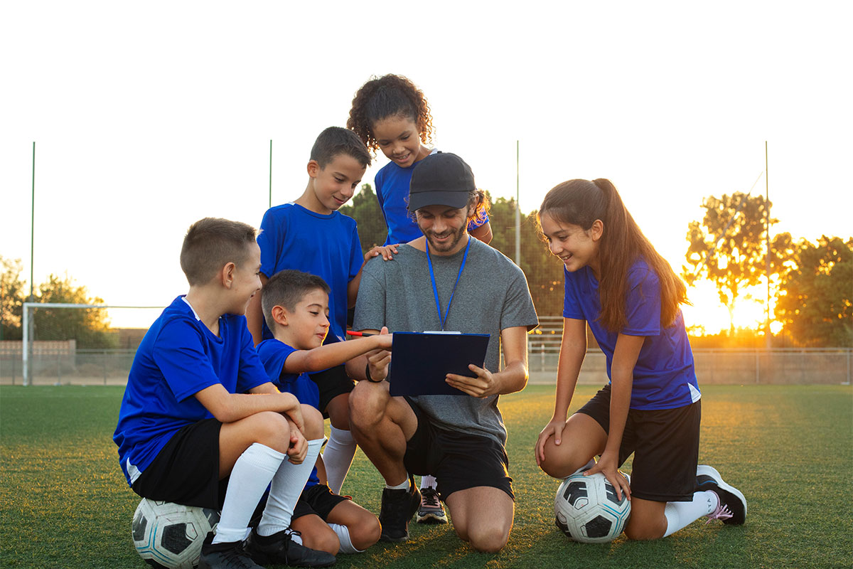 football-trainer-teaching-kids-front-view